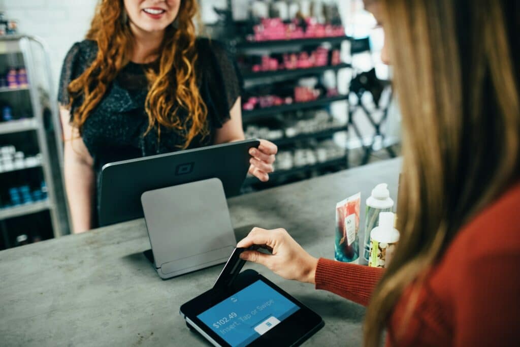 A woman swiping card on a processor at a business