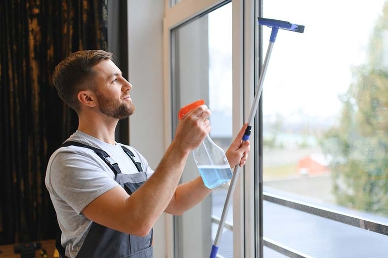 Cleaning service man holding window cleaning gear representing payment processing and point of sale technology for a cleaning service