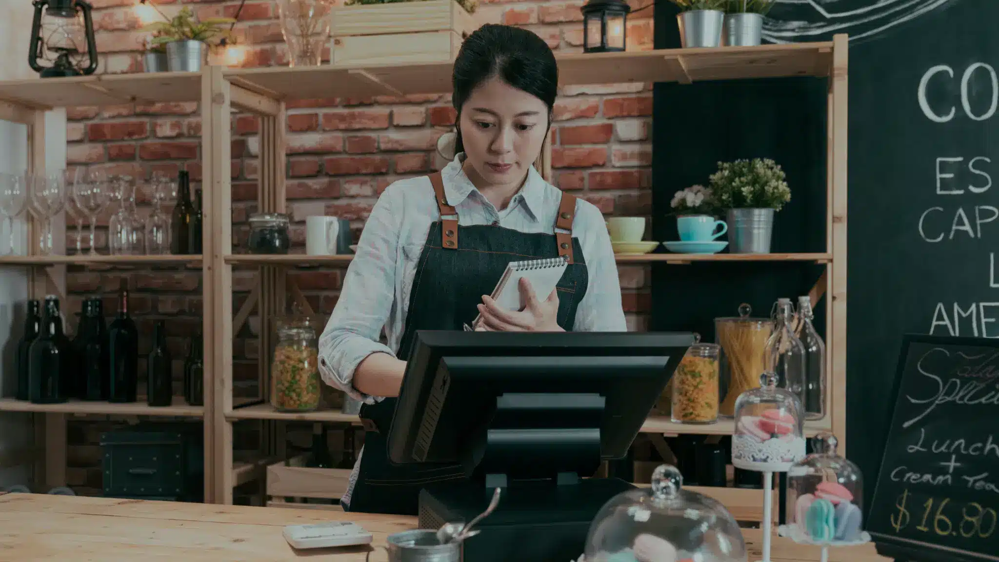 a barista processing a payment on a kiosk at a coffee shop