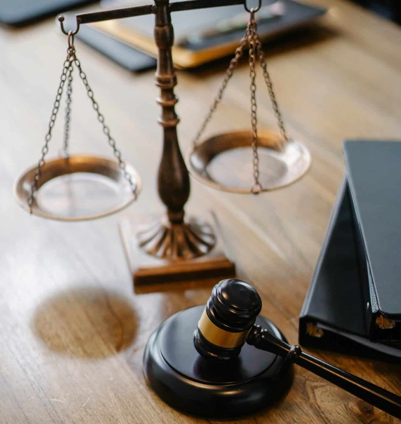 Gavel and legal scale on a desk with some books