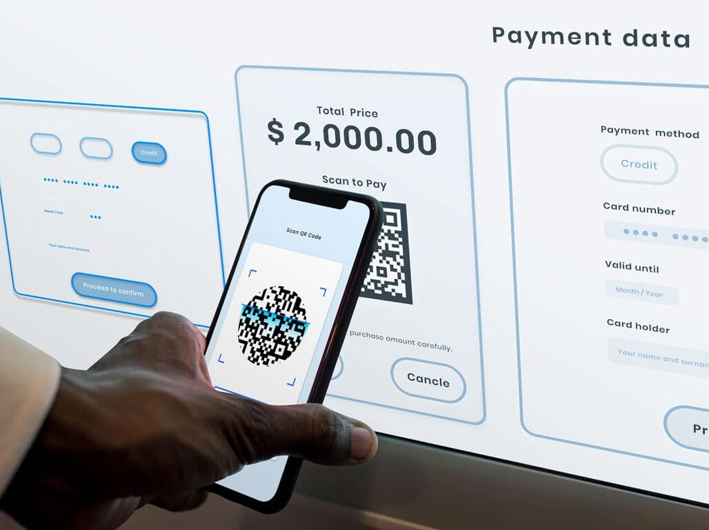 person using camera on phone to scan a qr code for payment on a computer screen