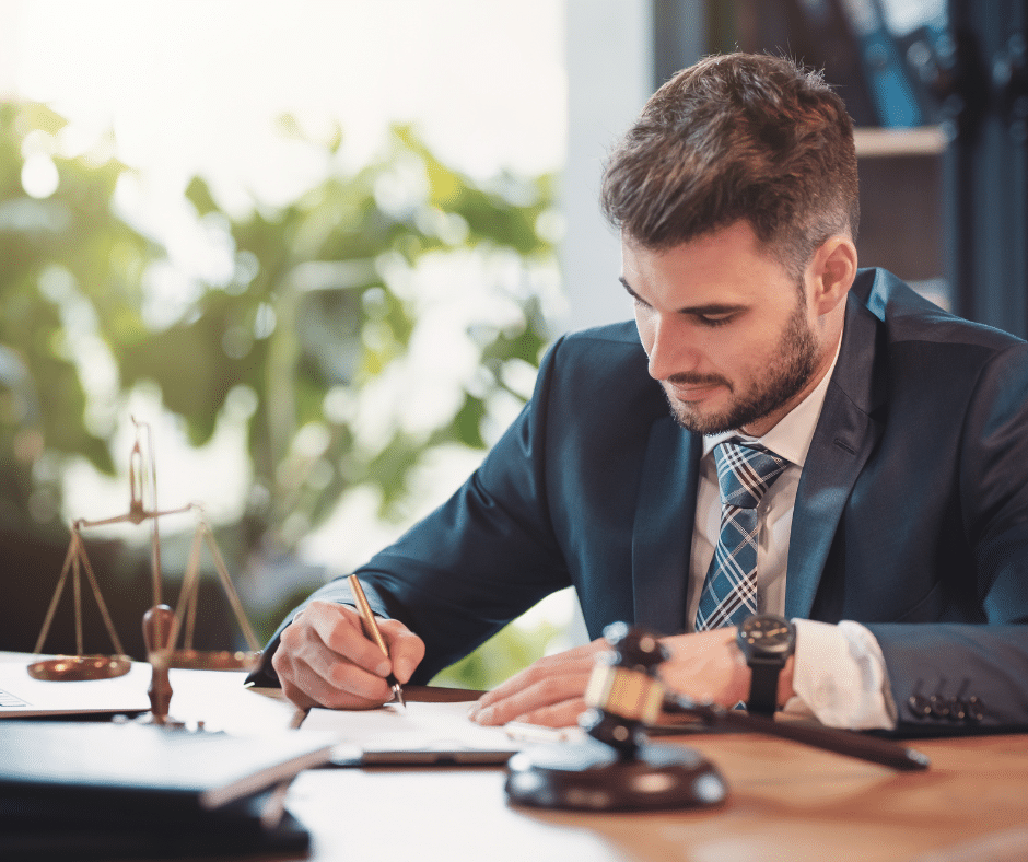 Man signing paperwork on his desk