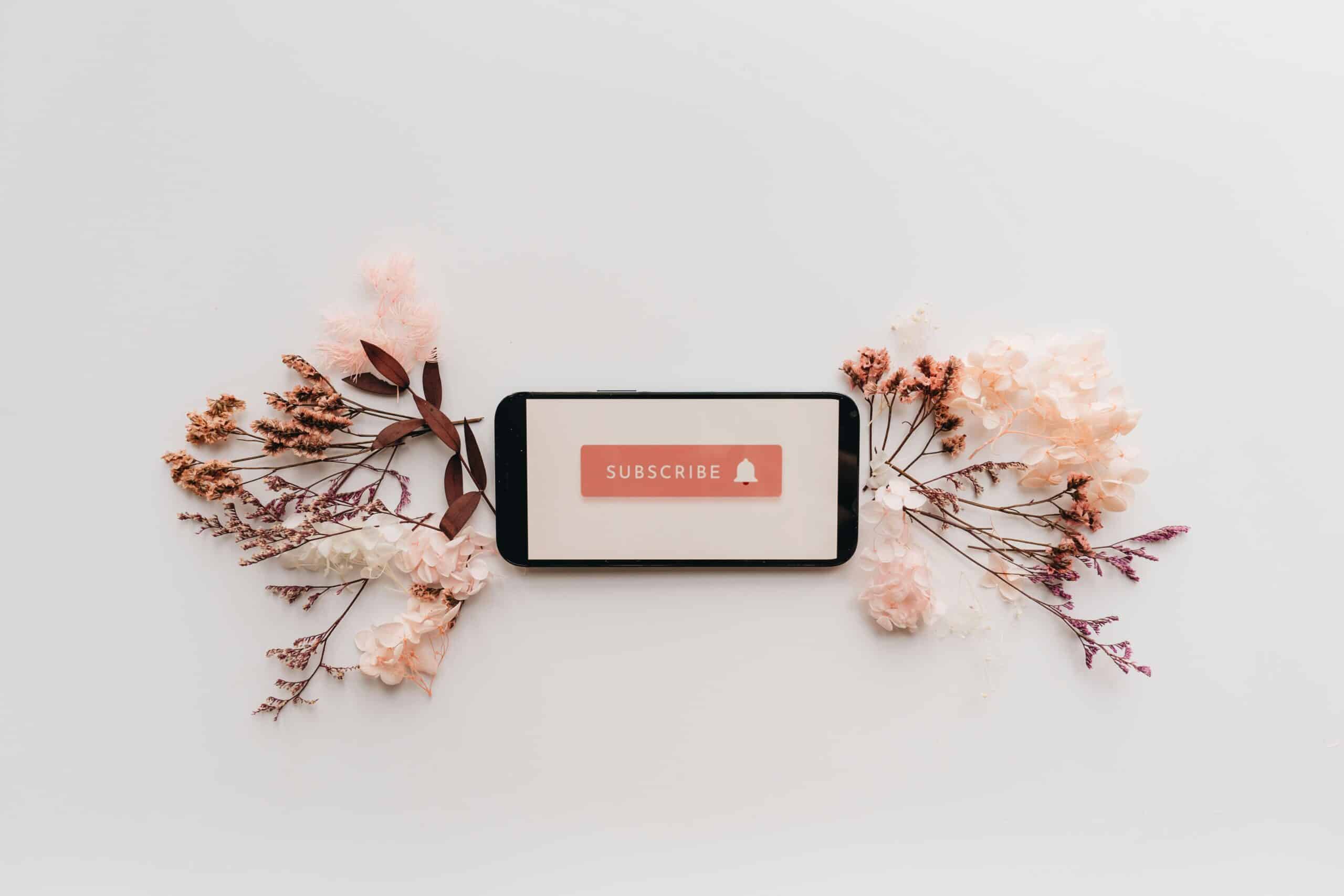 Subscribe text on a phone with florals indicating a subscription service