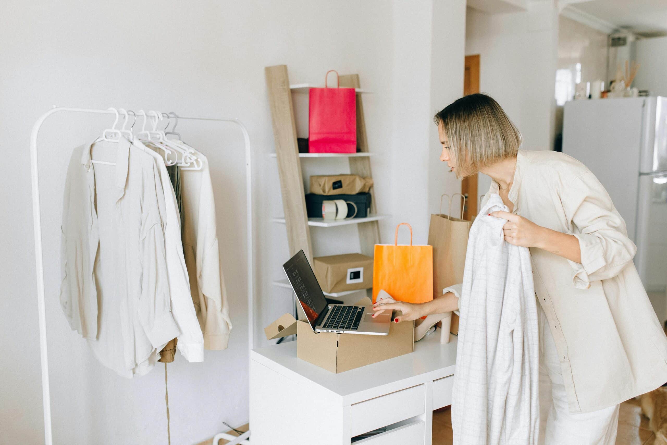 Woman with clothes display using laptop
