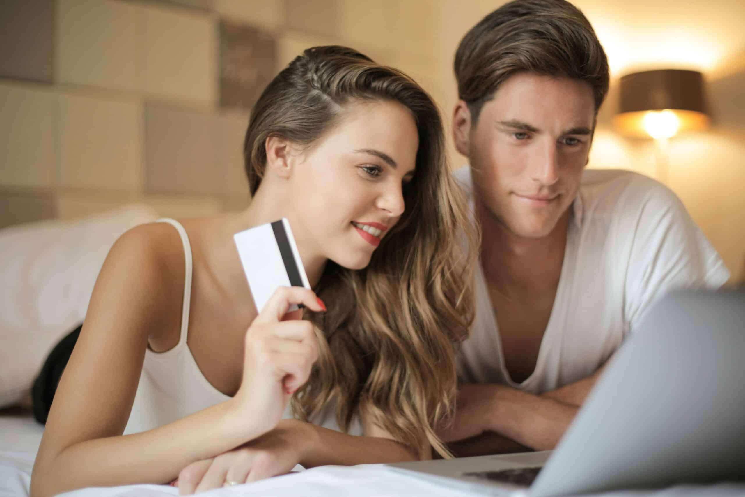 Man and woman using credit card on laptop
