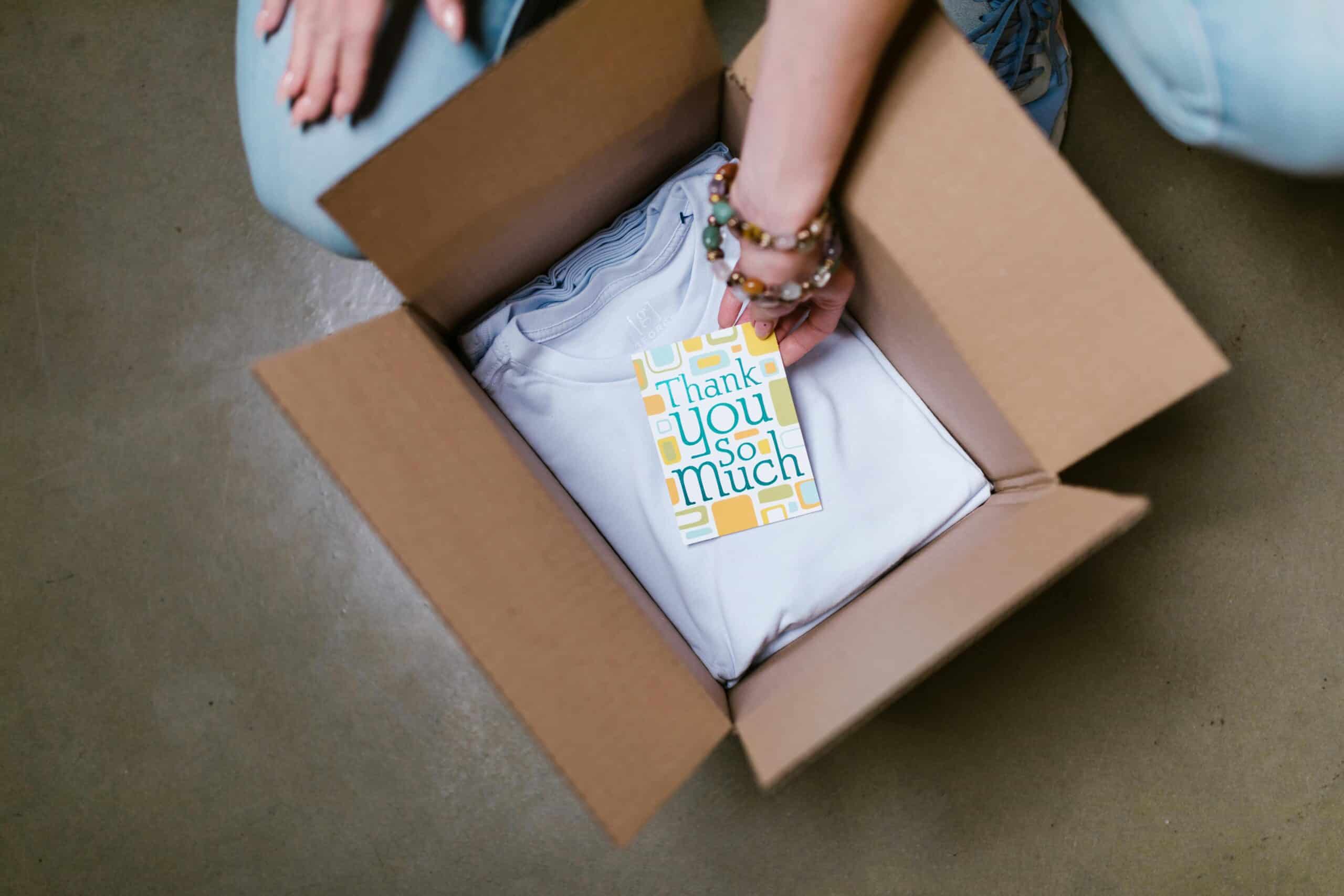 Someone opening a box with a thank you note indicating a recurring subscription service