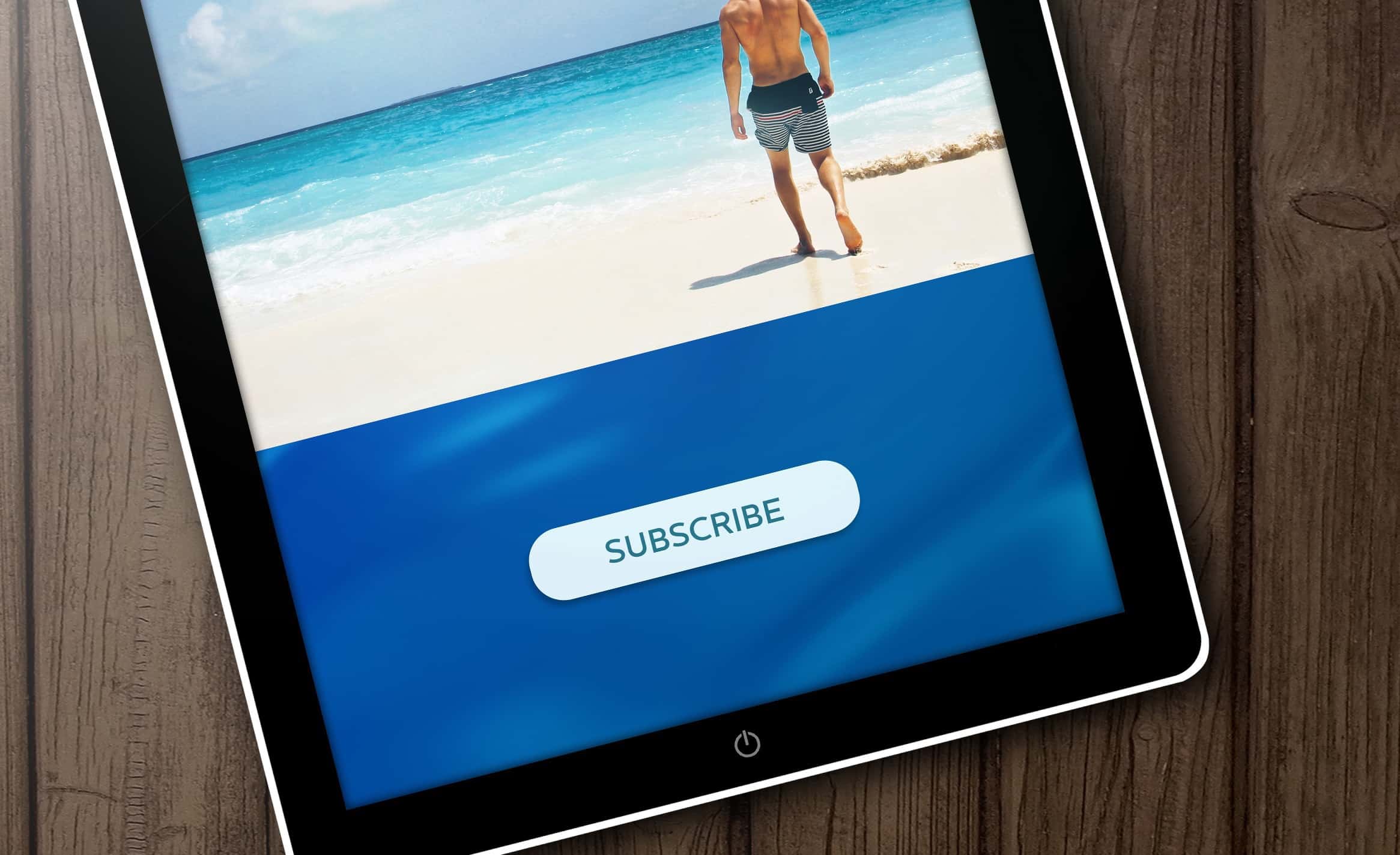 subscribe button on a tablet screen showing a beach scene