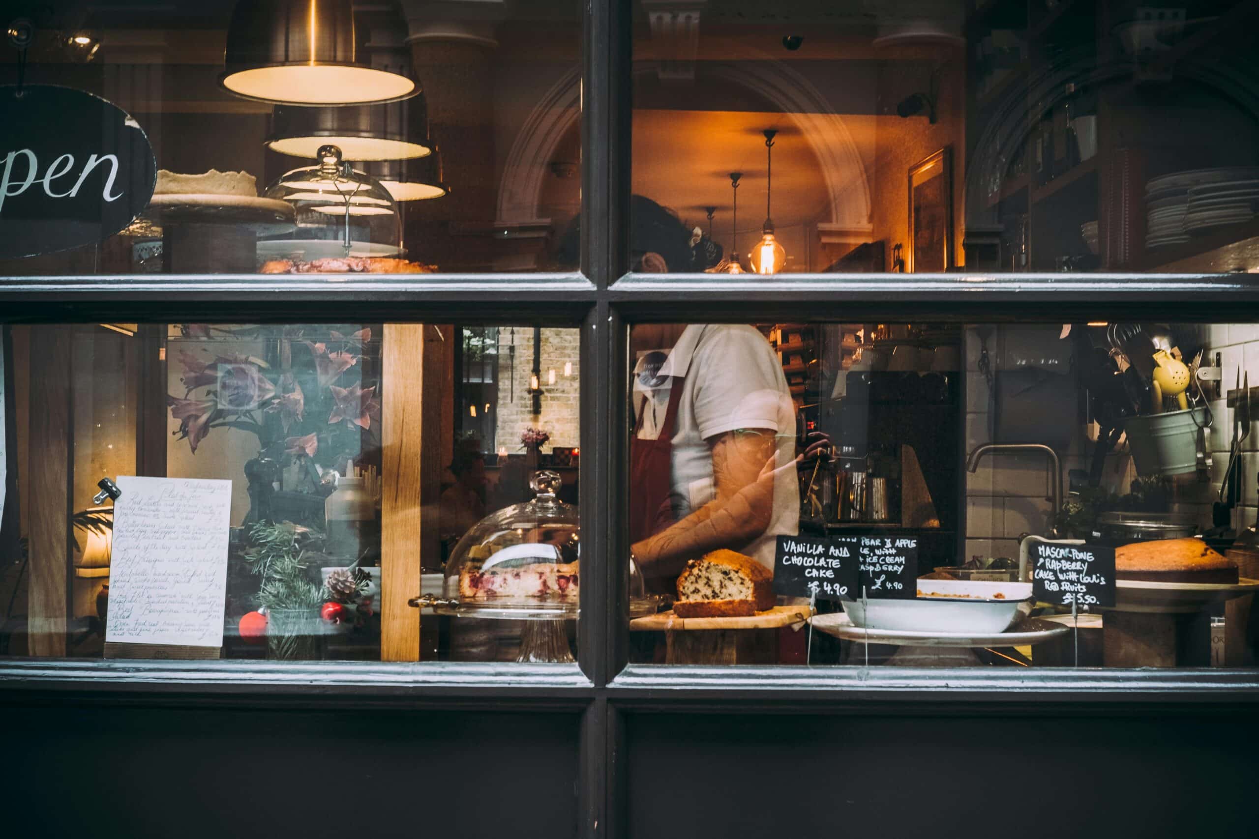 bakery seen through a window as someone in an apron prepares baked goods