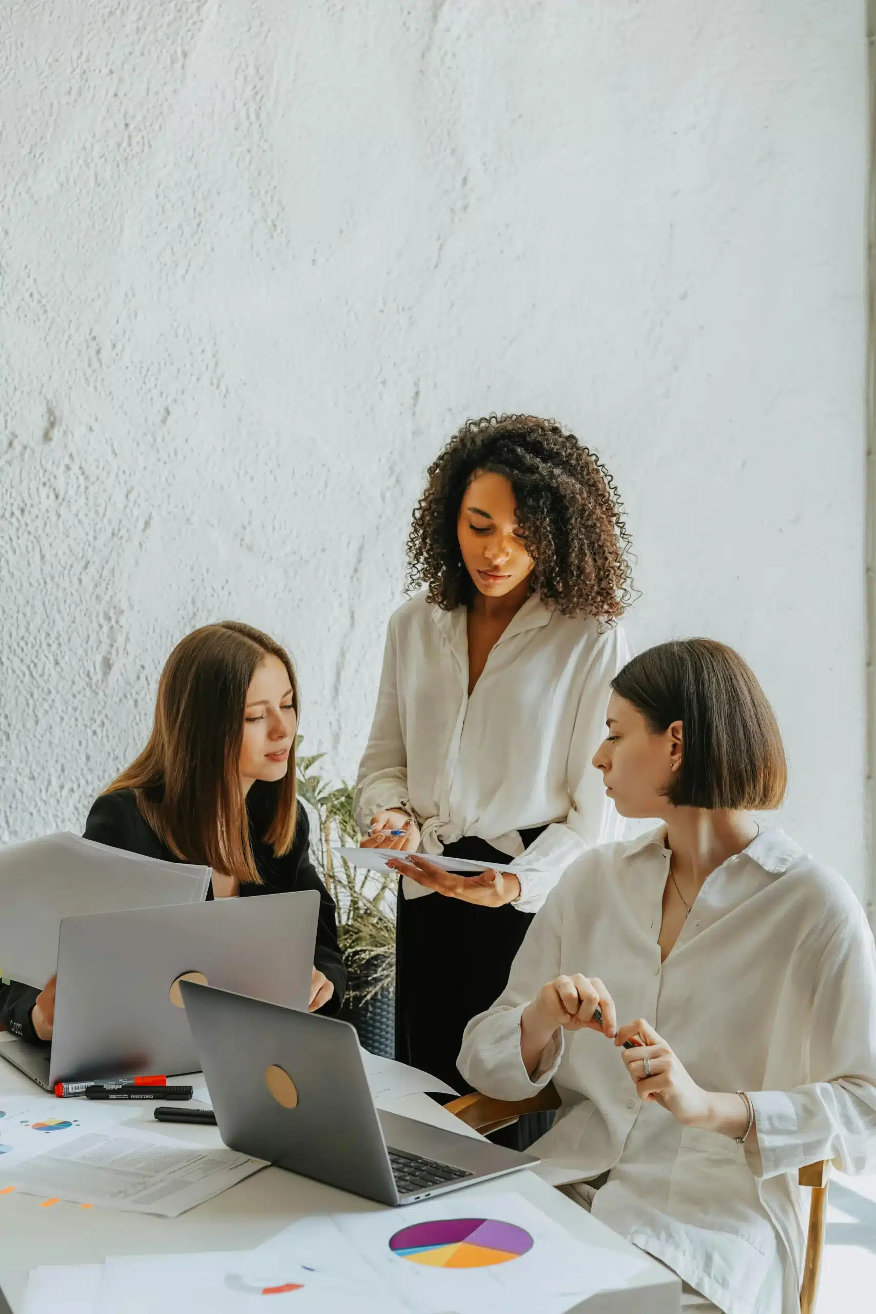 Three women in a meeting.